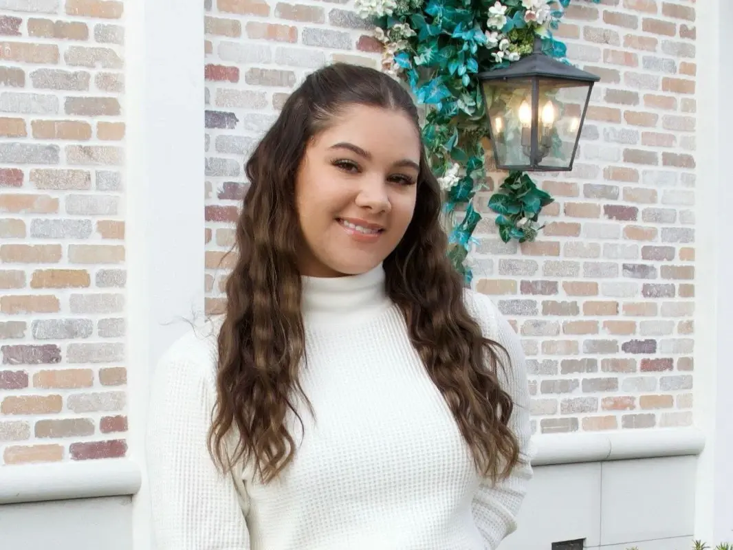 Photo of Madison Oliveri Standing in Front of a Brick Wall